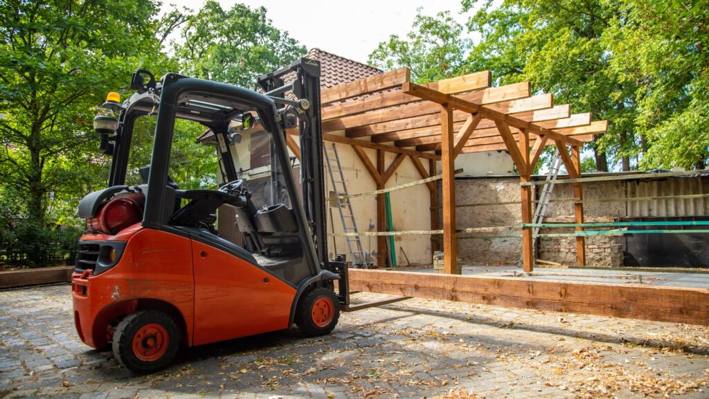 Mit Gabelstapler Holzbalken auf ein Carport heben